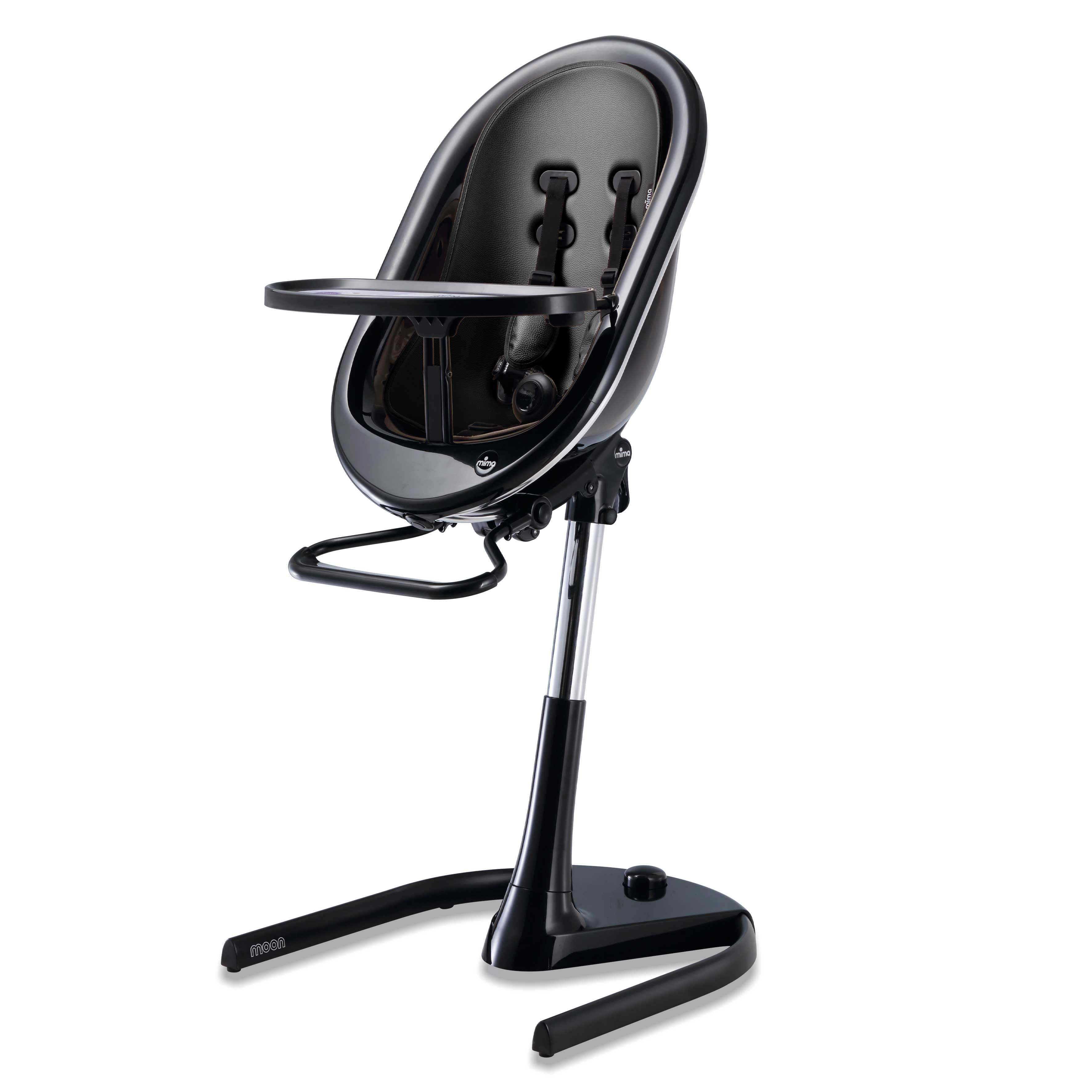 Black Mima Moon 2G high chair at max height, with black seat pad, tray, harness and adjustable footrest, right-front view