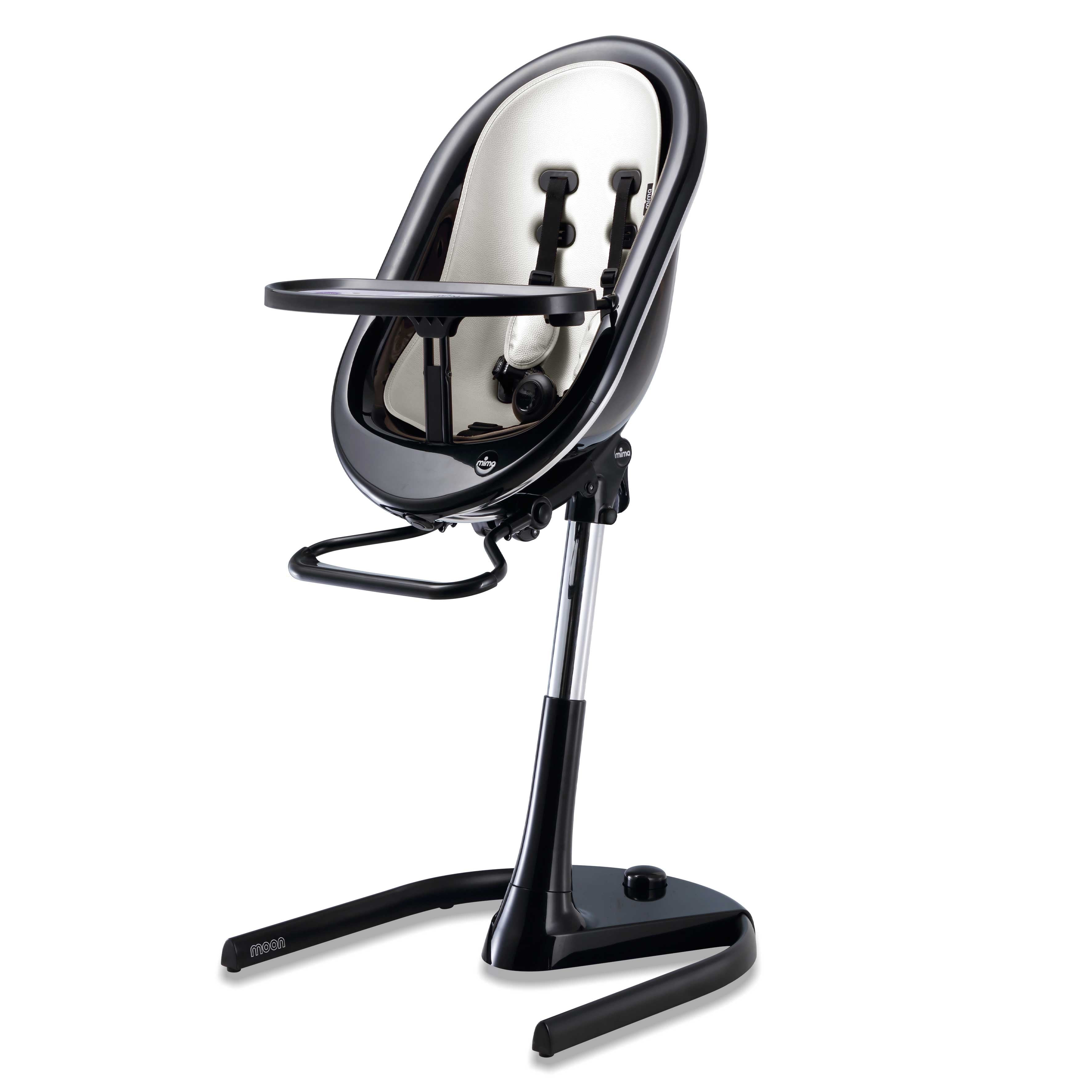 Black Mima Moon 2G high chair at max height, with snow white seat pad, tray, harness and adjustable footrest, right-front view