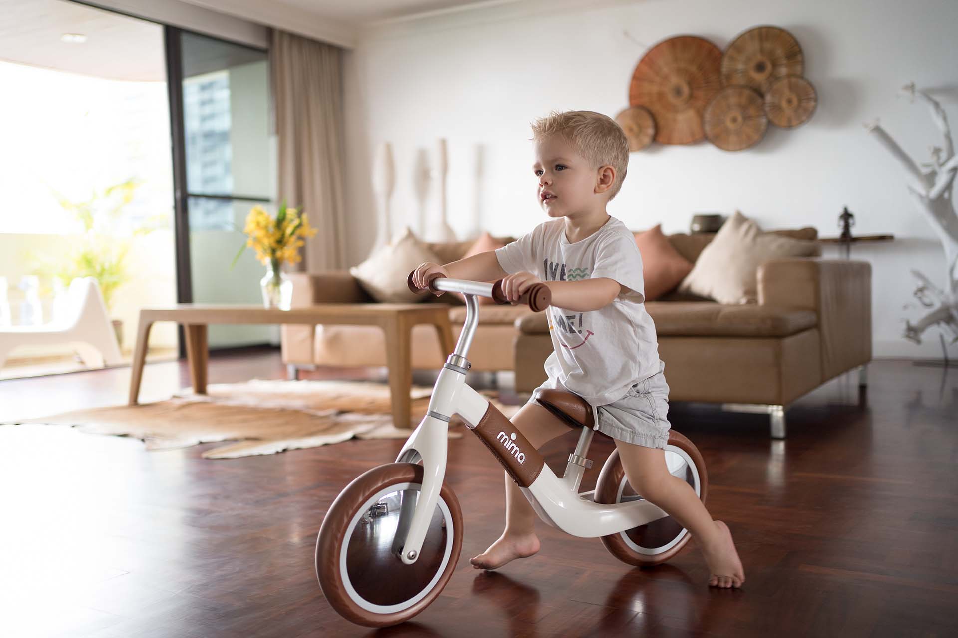 Boy riding Mima® Zoom White balance bike indoors at home