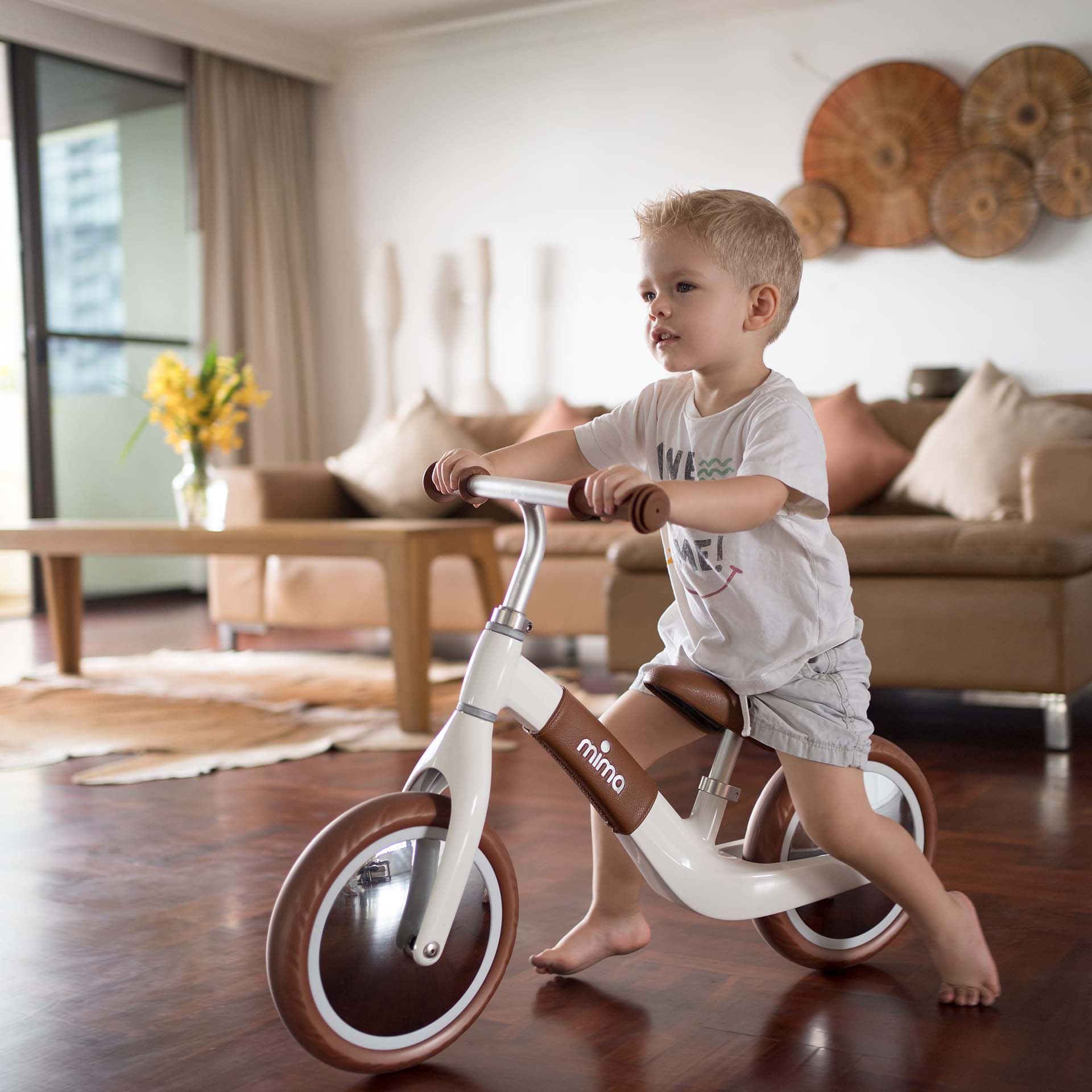 Boy riding Mima® Zoom White balance bike indoors at home