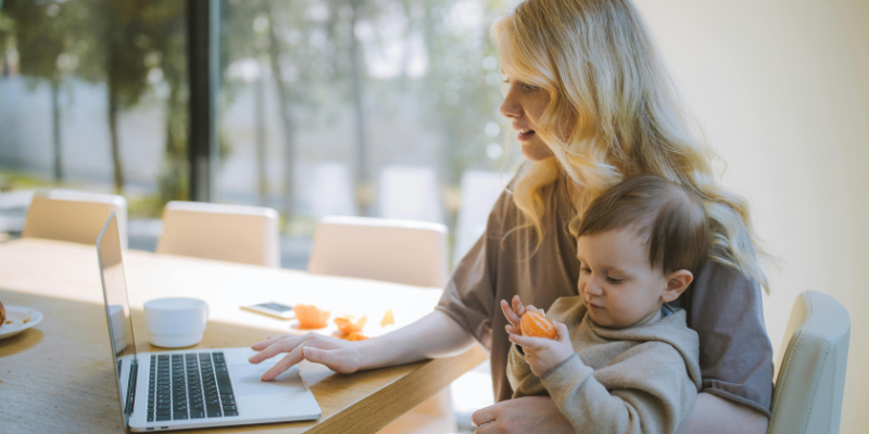 mother with baby on lap at the laptop From Registry to Reality: What New Parents Actually Use in the First 30 Days