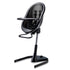 Black Mima Moon 2G high chair at max height, with black seat pad, tray, harness and adjustable footrest, right-front view 