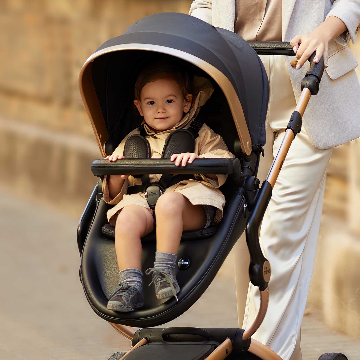 Mima® Xari Max Black & Gold Special Edition Stroller with a child on a city street, featuring a sleek black and gold design with a luxurious canopy, perfect for stylish urban parents.