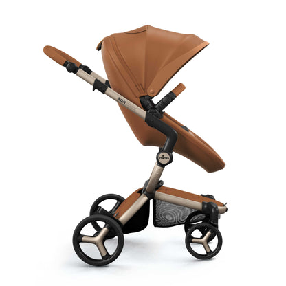 mima® xari max stroller, in champagne chassis, camel seat and black seat pad, with canopy and safety bar, facing forward, side view 