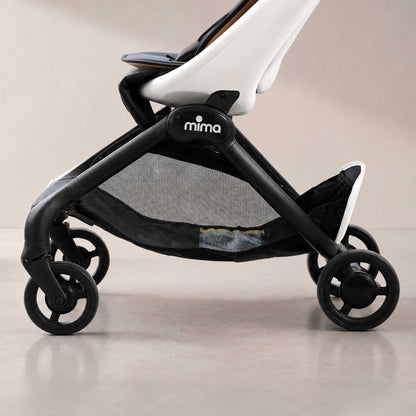 side detail view of chassis and storage basket on mima miro compact travel stroller in white 