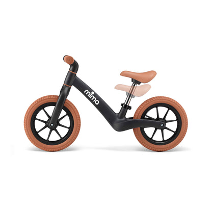 side view of mima zoom lite balance bike in black showing adjustable seat height with faded overlay 